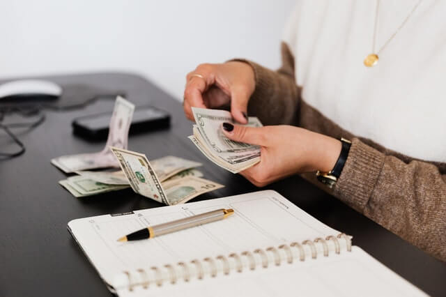 Timely Tax Tips crop payroll clerk counting money while sitting at table